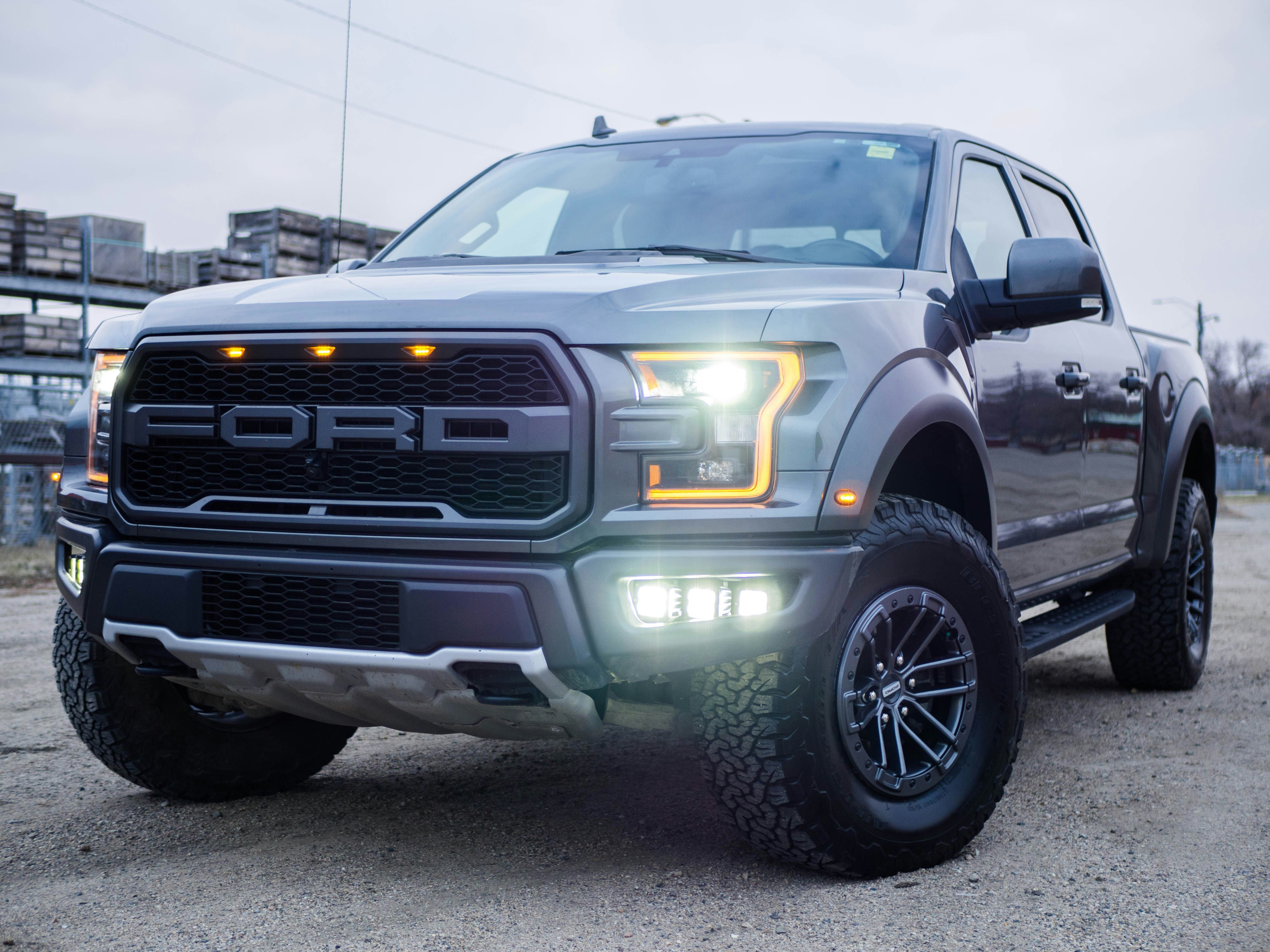 Silver Ford Raptor pickup, front three-quarter view, amber running lights on